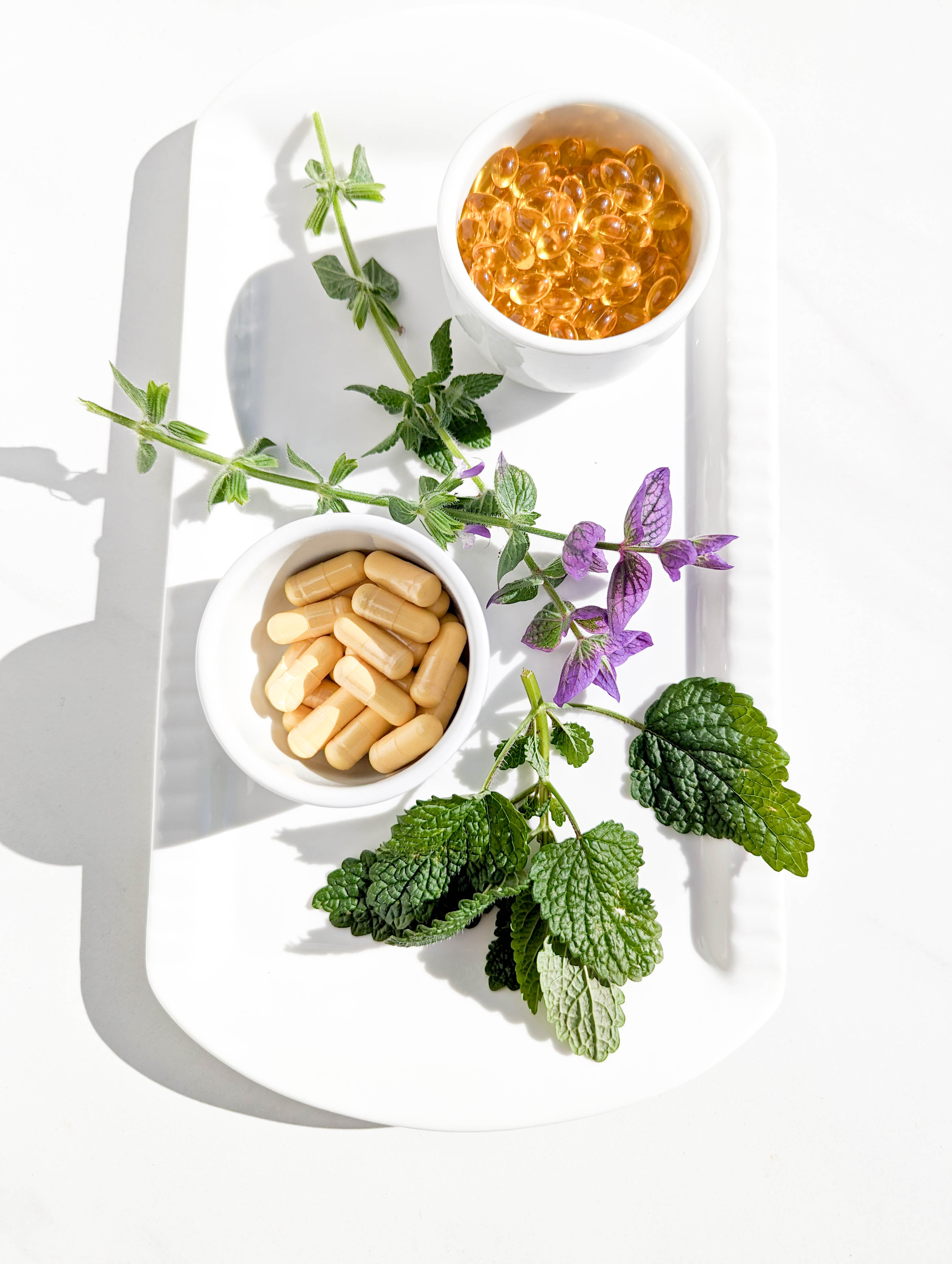 supplements with herbs on white platter
