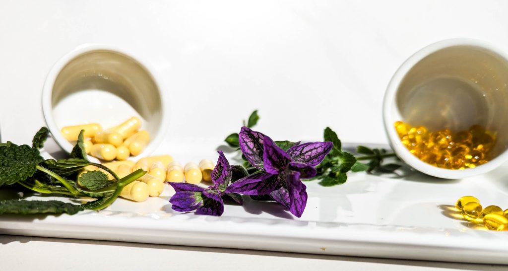 capsules and flowers on white serving dish