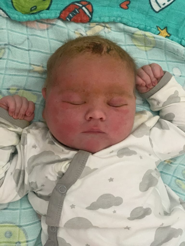 newborn baby in cloud onsie