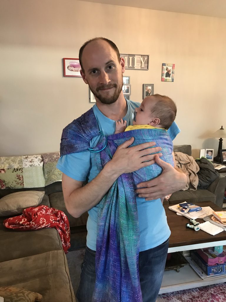 man baby wearing with a blue handwoven ring sling