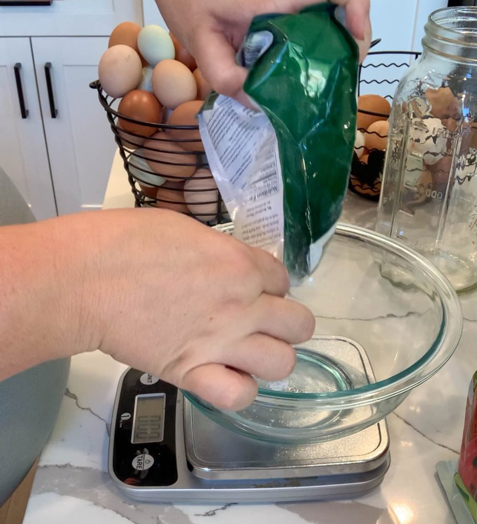 measuring pickling lime into bowl on kitchen scale