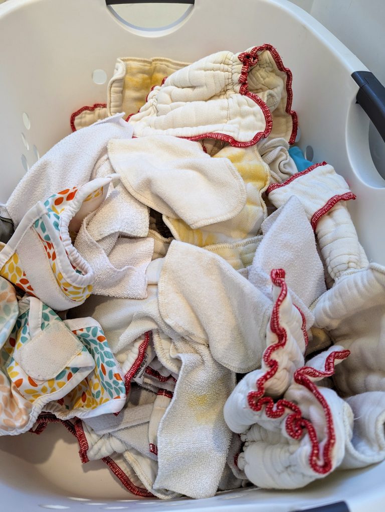 Clean and dry cloth diapers in white hamper