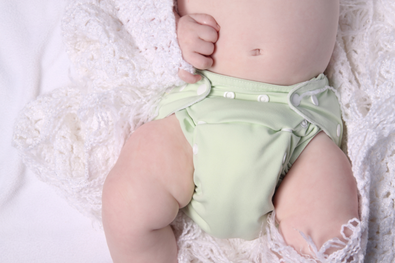 baby in green cloth diaper