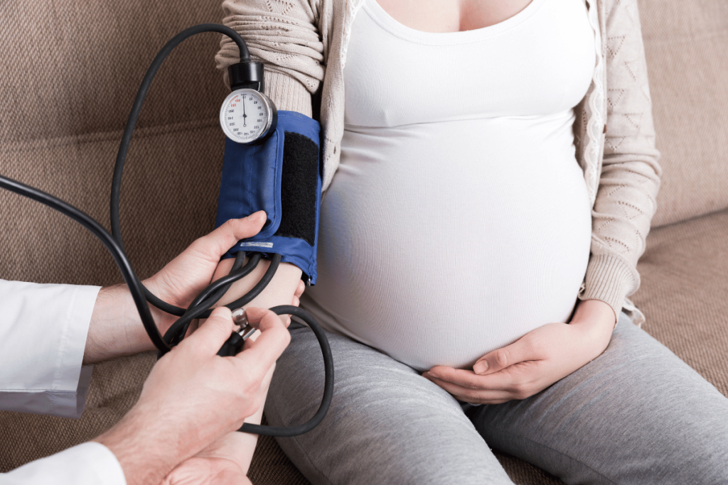 pregnant woman in white shirt with blood pressure cuff