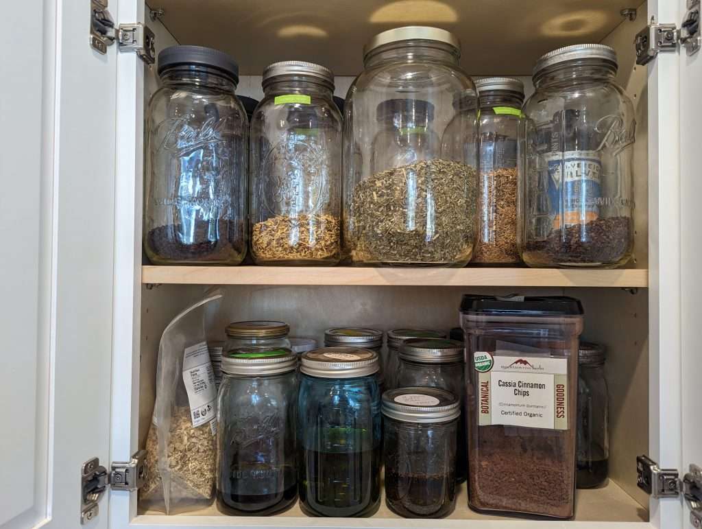 herbs in glass jars in a medicine cabinet