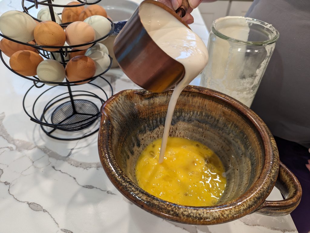 sourdough discard pouring into ceramic bowl