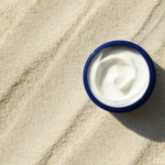 Natural sunscreen in blue bowl on sand