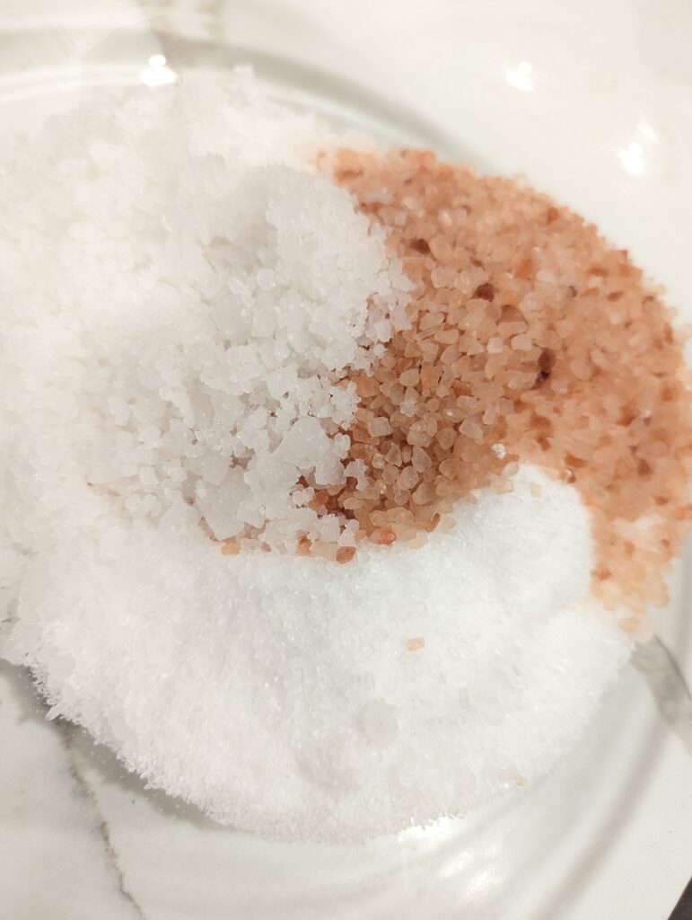 pink himalyan salt, epsom salt, magnesium chloride flakes in glass bowl