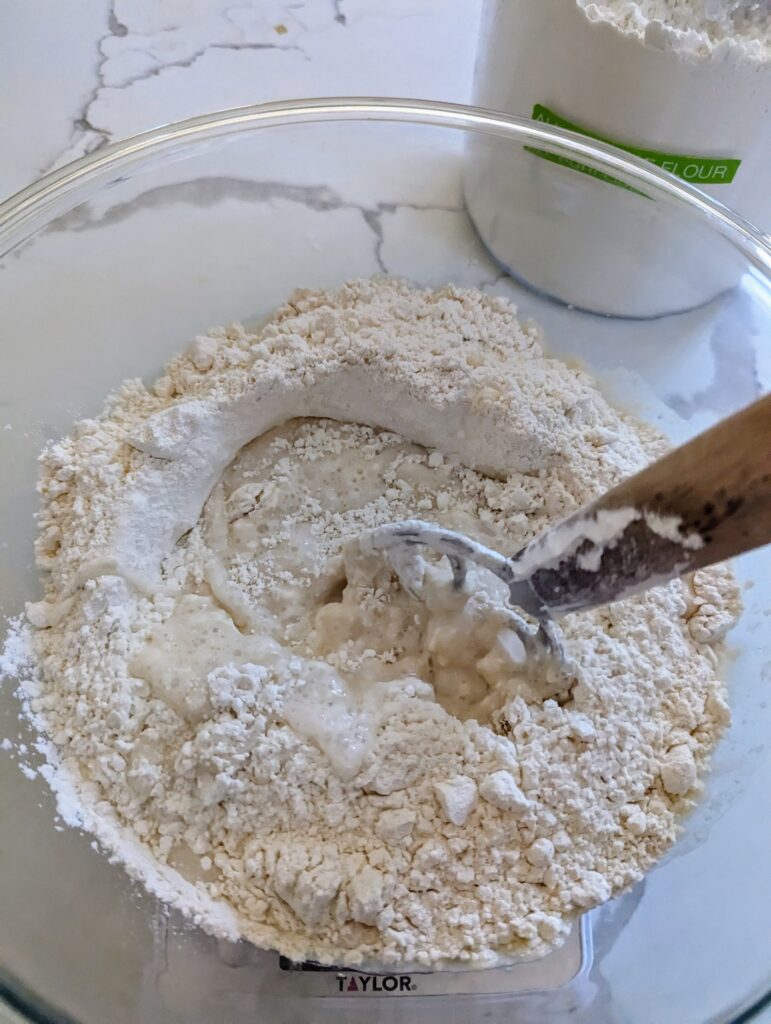 sourdough focaccia garden bread mixing in glass bowl