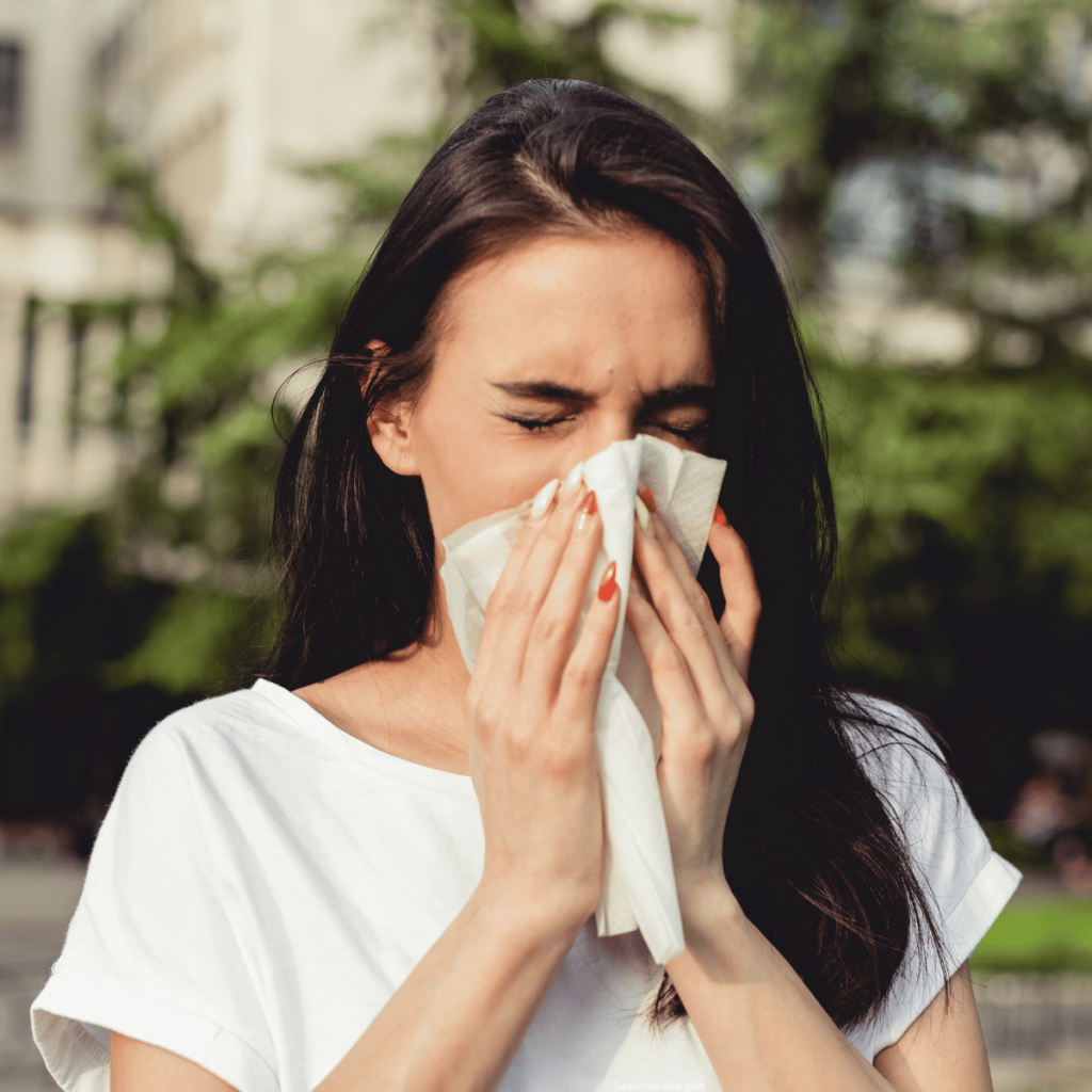 seasonal allergies woman blowing nose into tissue