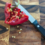 how to save pepper seeds with bell pepper and knife on wood cutting board