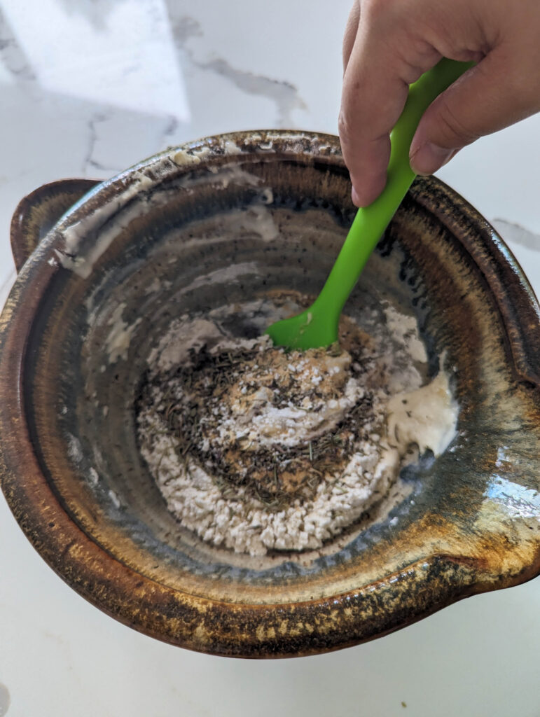 mixing herbs into sourdough herb cracker dough