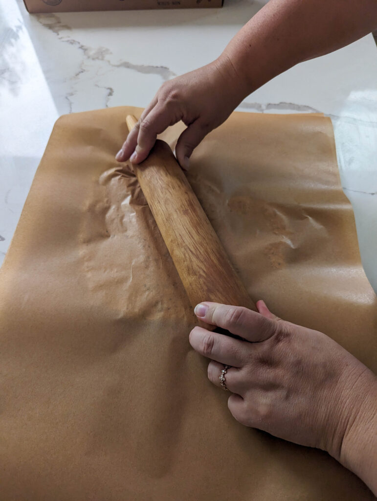 wooden rolling pin over parchment paper