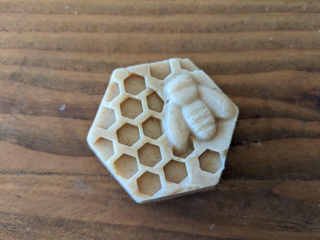 hexagon honeycomb and bee soap on wood countertop