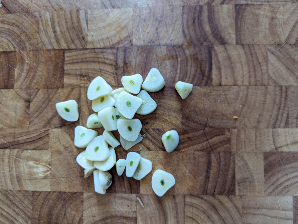 fresh garlic chopped on wood cutting board