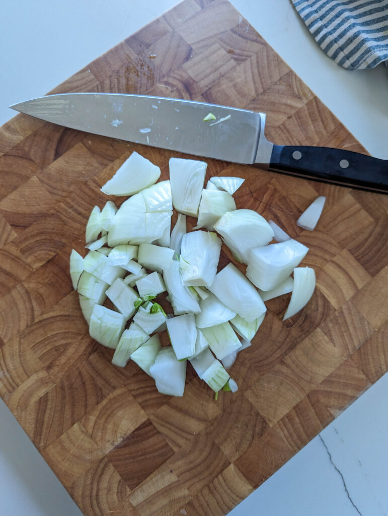 chopped onions on wood cutting board with knife