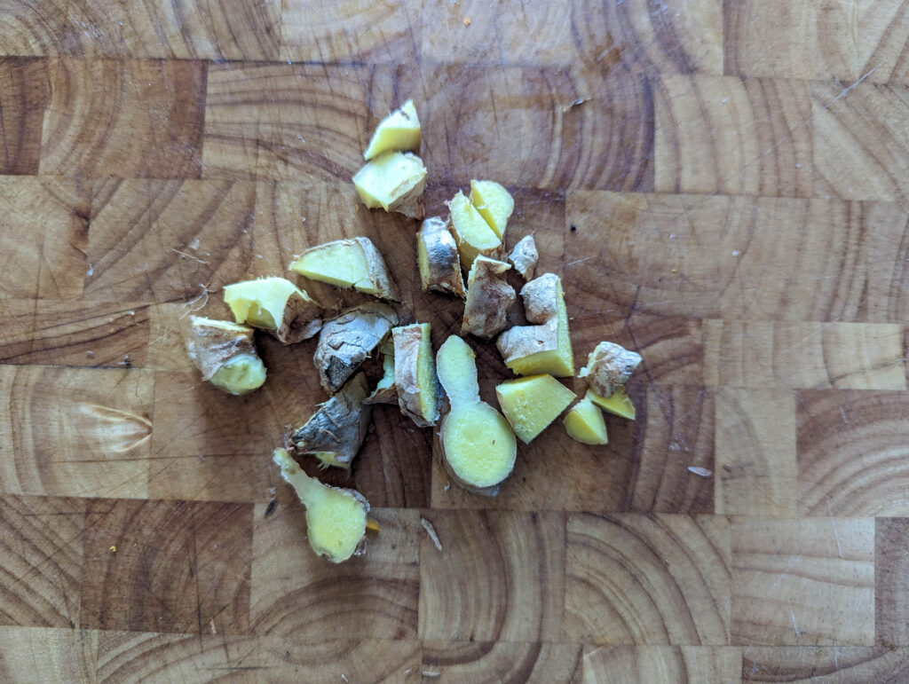 chopped fresh ginger root on wood cutting board