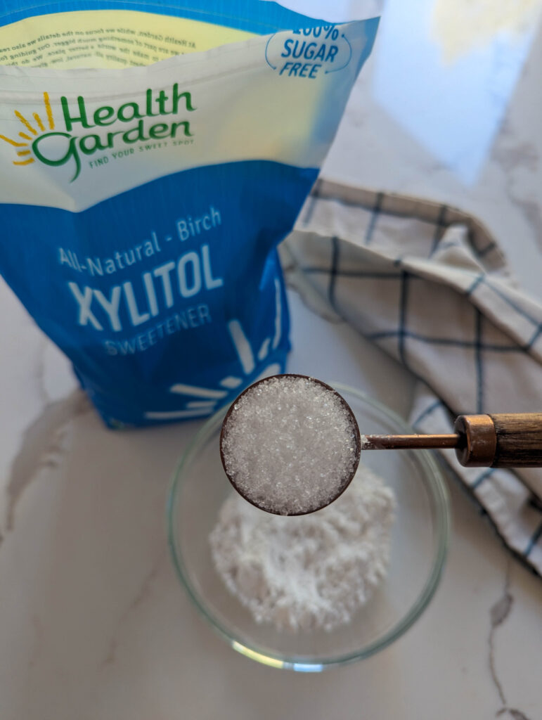 xylitol in a bag andon a copper measuring spoon