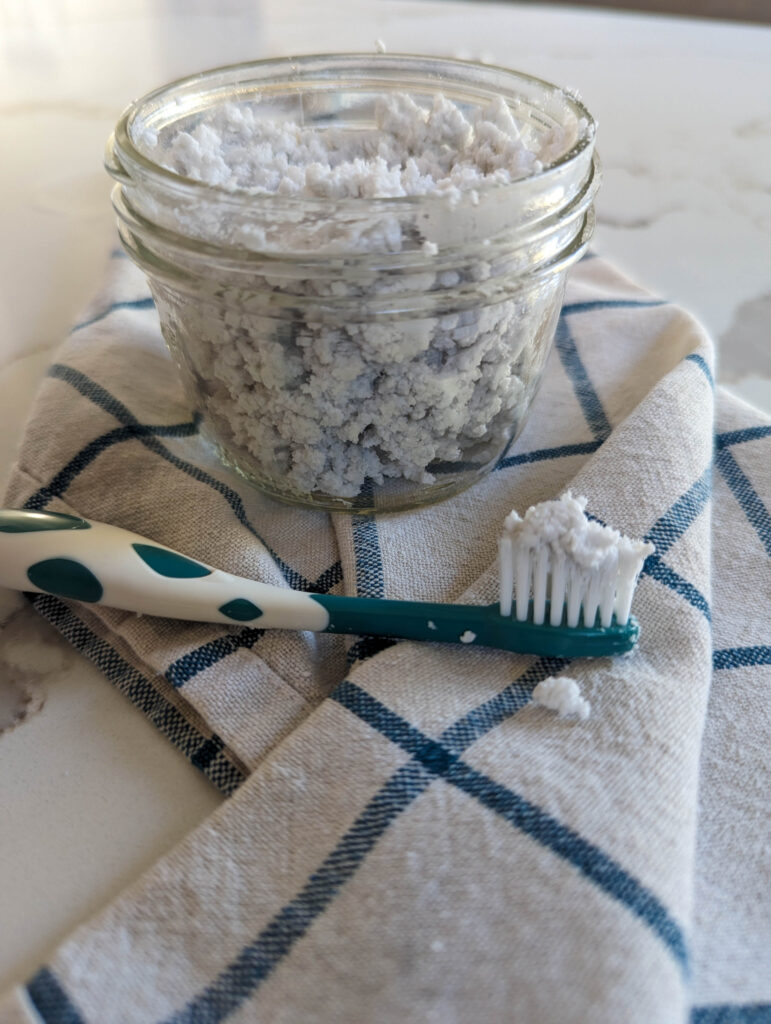 homemade natural toothpaste in glass mason jar with toothbrush