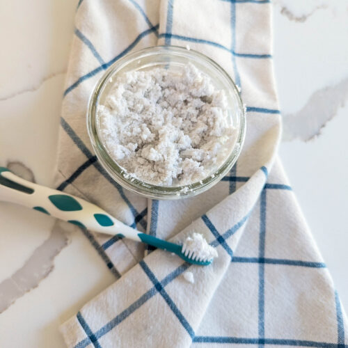 homemade toothpaste in mason jar with tooth brush and towel