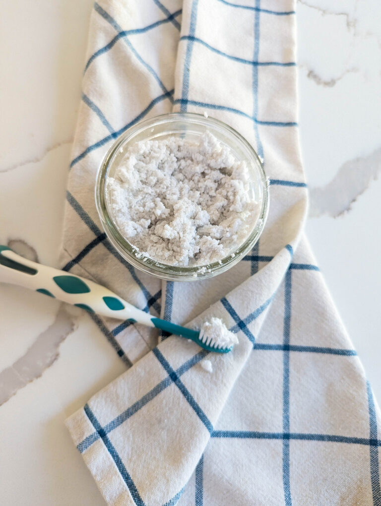 homemade toothpaste in mason jar with tooth brush and towel