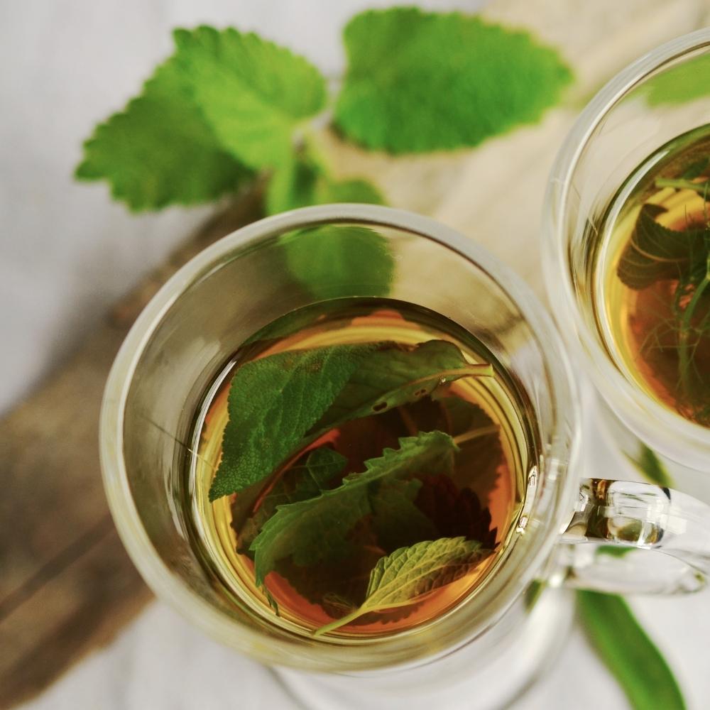 peppermint herbal tea in a glass mug with peppermint leaves