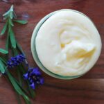 magnesium lotion with lavender flowers on wood