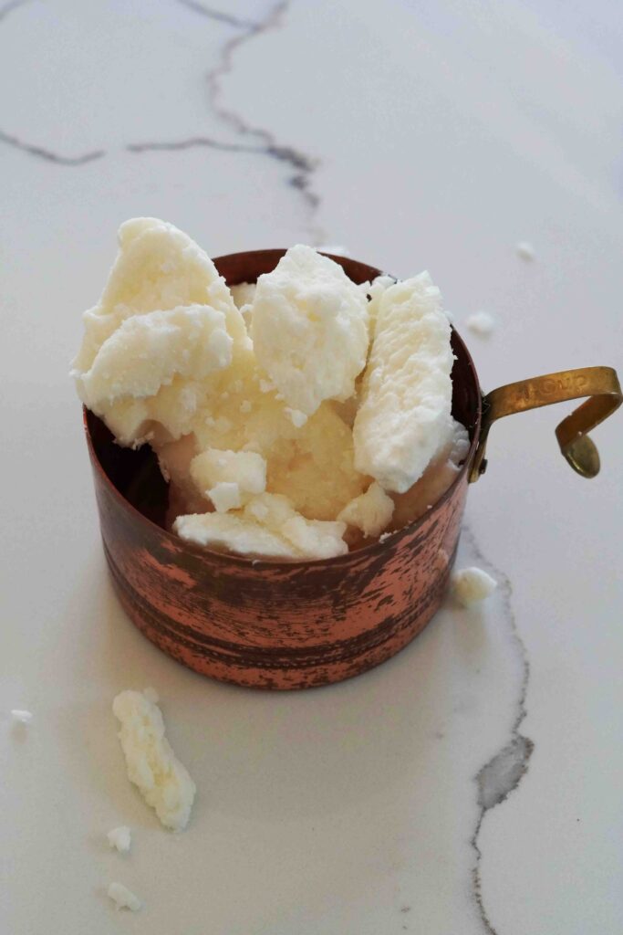 shea butter in copper measuring cup