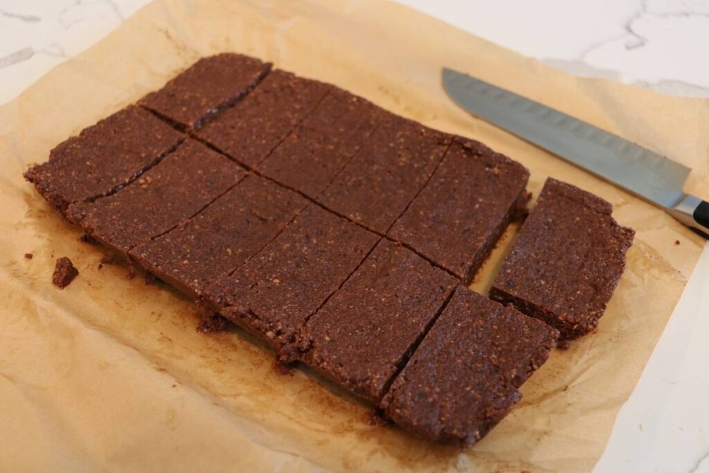 easy homemade chocolate larabars on parchment paper with knife cut into pieces