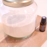 natural homemade powdered laundry detergent in glass jar and peppermint essential oil