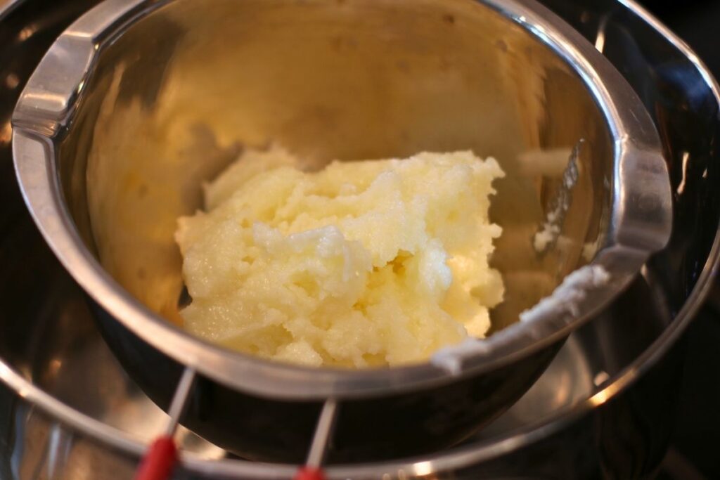 melting chamomile coconut herbal oil in double boiler